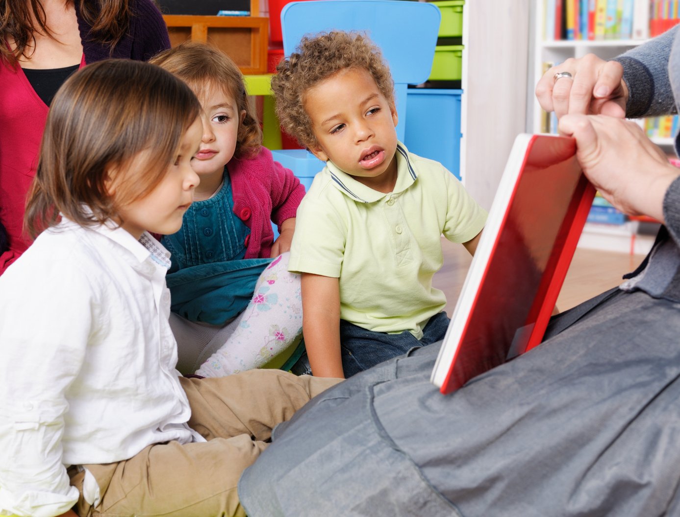 Group Of Little Children Looking Into A Book During Storytime