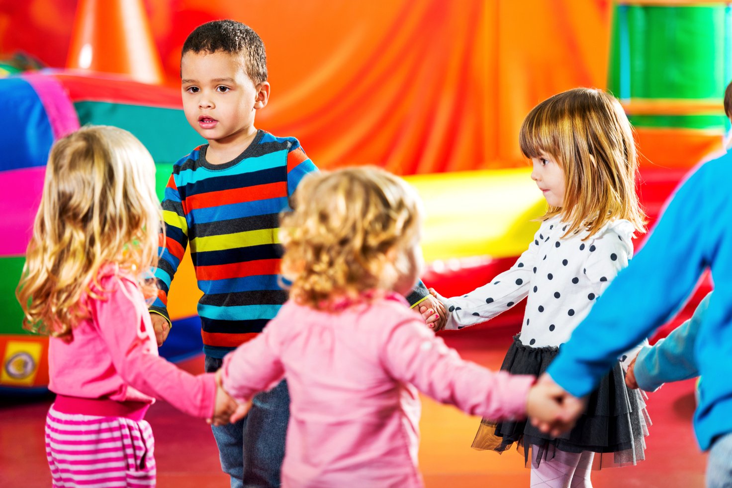 Children dancing in a playroom.